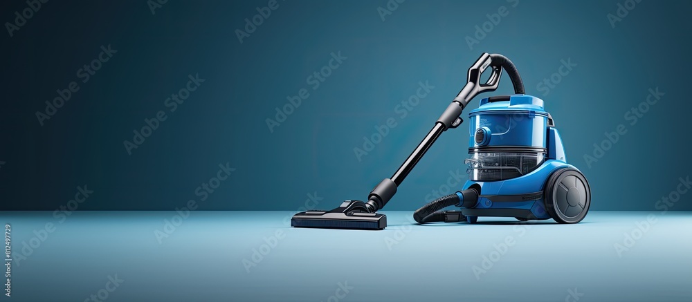 Poster copy space image of a vacuum cleaner placed on a blue background with a rug underneath it