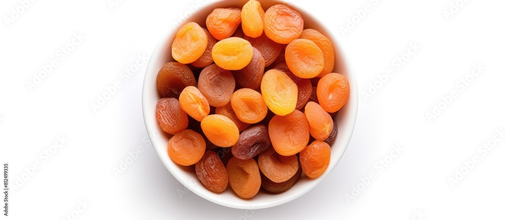 Poster copy space image of a top view bowl filled with dried apricots on a white background offering a heal