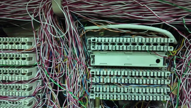 Inside a PABX telephone booth that has a number of connecting cables in many colors in the analog system. communication technology