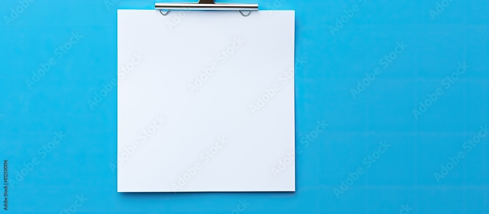 Leinwandbilder isolated on a blue background there is a white paper note held in place by a paper clip the image of