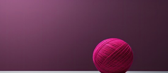 Fototapeta premium A large magenta ball of thread stands out against a gray background leaving plenty of space for an image. Creative banner. Copyspace image