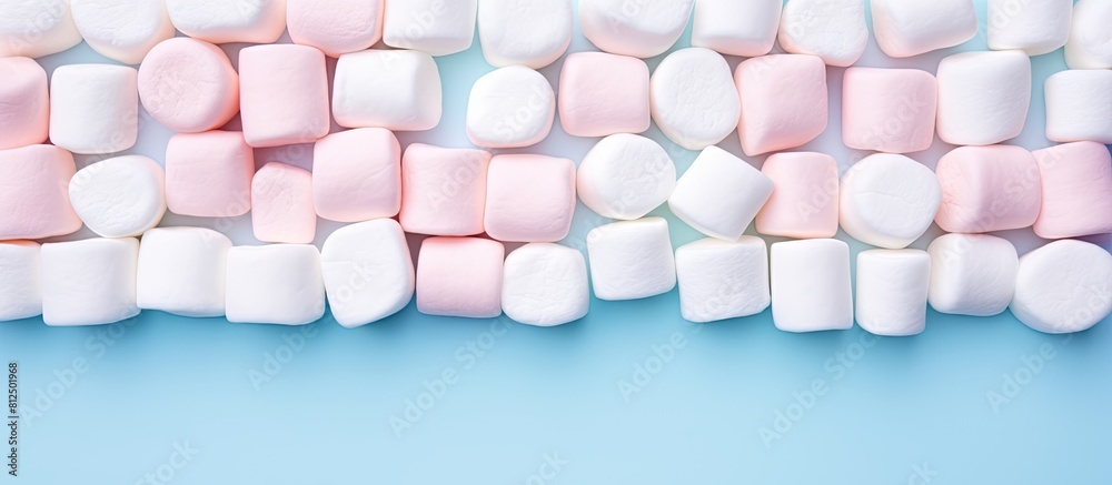 Aufkleber marshmallows arranged in a flat lay composition with a copy space frame on a pastel pink and blue ba