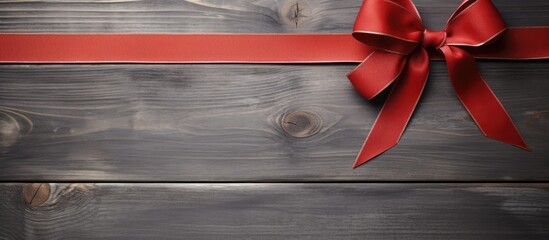A minimal concept with a copy space image featuring a grey background adorned with a vibrant red bow perfect for Christmas or New Year cards