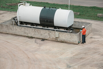 Top view male workers are for check record inspection of storage tank