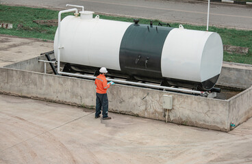 Top view male workers are for check record inspection of storage tank