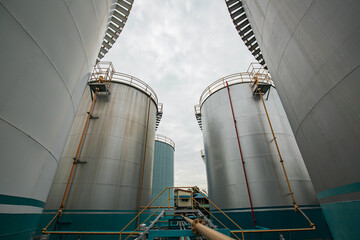 Tank farm in industry Thailand with white oil and petrol silos under blue