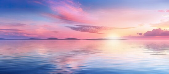 Fototapeta premium A serene blue and pink sunset reflecting on the tranquil water creating a captivating copy space image