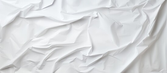 Obraz premium A slightly crumpled white sheet of paper is showcased up close on a white background offering plenty of copy space for inscriptions words and graphics