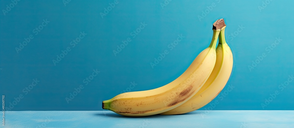 Poster Studio shot of a banana on a blue background with copy space image