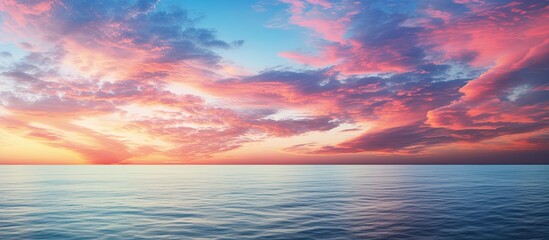A stunning seascape at sunrise with colorful clouds over the ocean creating a picturesque image with plenty of copy space