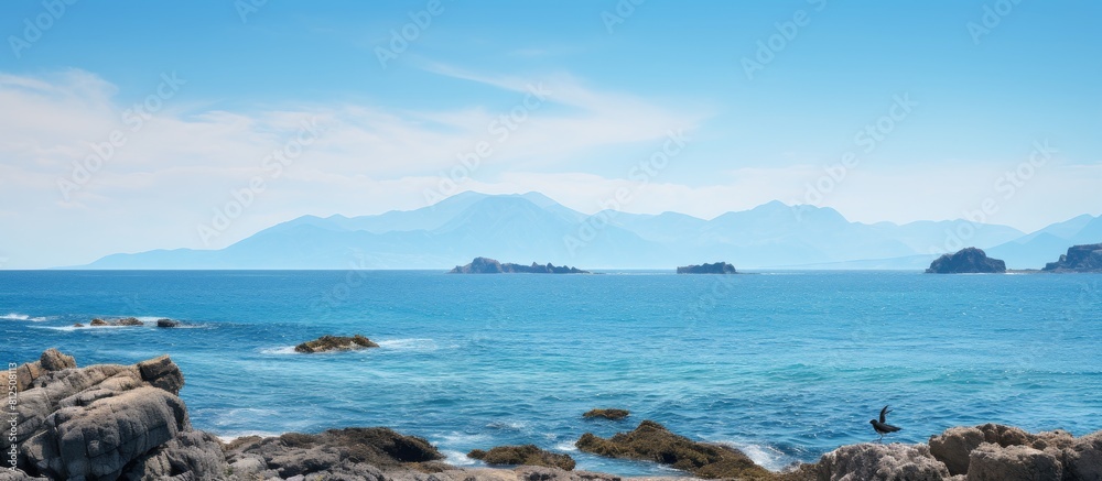 Aufkleber a stunning seascape featuring a rocky mountain in the foreground with a bird gracefully perched in f