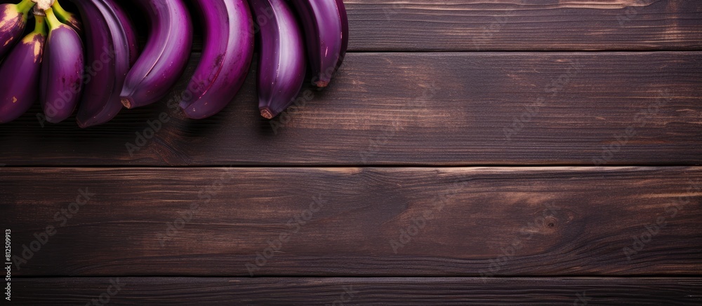Poster Top view of a wooden table adorned with delicious purple bananas creating a visually appealing copy space image