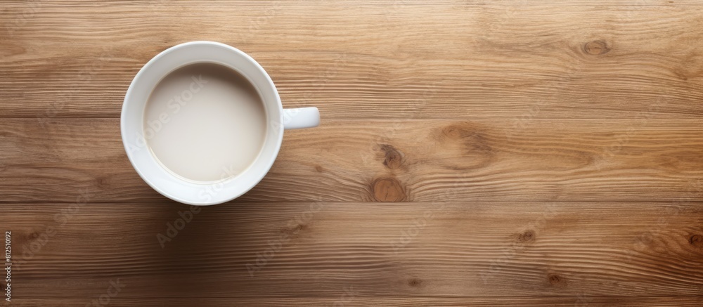 Poster Top view of a white cup placed on a wooden surface showcasing an empty space in the image. Creative banner. Copyspace image