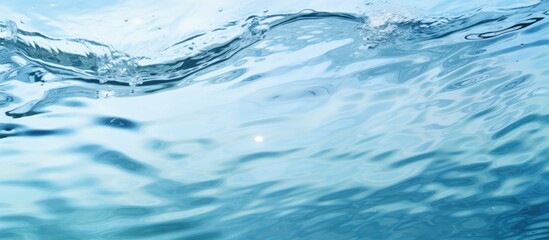 Top view of a clear water surface with rippling patterns set against a light blue background creating a visually appealing copy space image