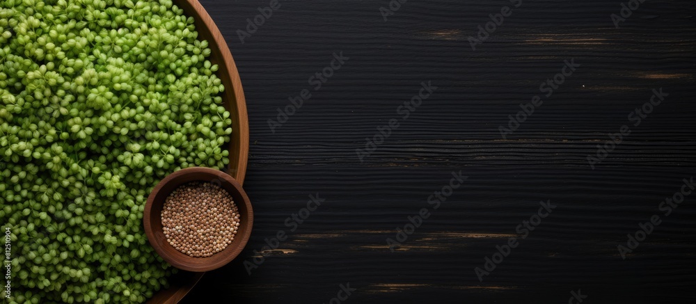 Poster top view of raw green buckwheat on a black wooden background with plenty of copy space for an image