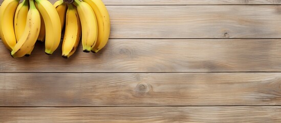 A top view of three ripe bananas placed on a light wooden background leaving empty space for additional images or text