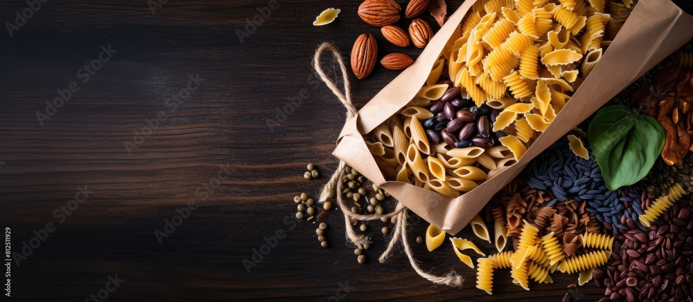Poster A variety of colorful pasta is scattered on a white background inside a disposable brown kraft paper bag The image is captured from a top down perspective and there is ample empty space for text