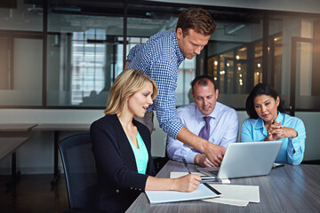 Teamwork, laptop and business people in meeting, collaboration and brainstorming with planning. Startup, group and employees with computer, cooperation and partnership with research, project and talk