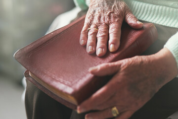Senior woman, hand and bible with prayer for worship, faith and spiritual healing at home. God,...