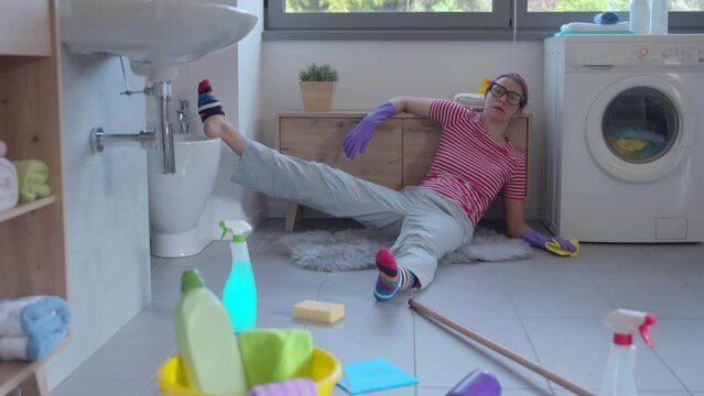 Exhausted messy woman lying on the floor, she cleaned up her home