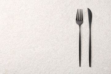 Stylish cutlery on beige textured table, top view. Space for text