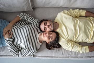 Couple in peaceful pose on sofa with faces together closed eyes. Intimate relaxation, tender time....