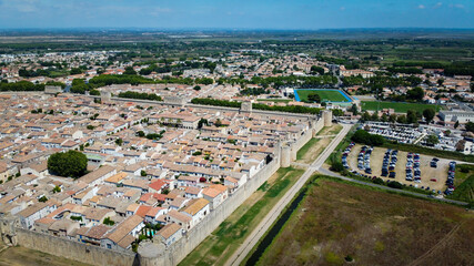 Obraz premium Fortified city of Aigues-Mortes, in Provence in France. Entirely surrounded by an imposing city wall and purple salt pans of incredible beauty, Aigues-Mortes is a jewel, an enchanting medieval village