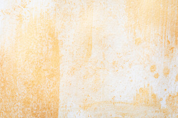 Golden paint creates an abstract pattern on a textured white paper surface. Golden glitter background