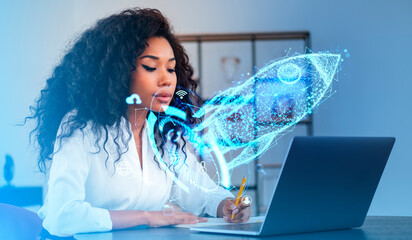 African businesswoman take note and working with laptop, glowing rocket hologram