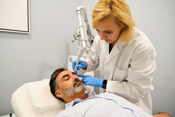 A man is getting a Non-Surgical Eyelid Lift or blepharoplasty, lifting laser eyelid.