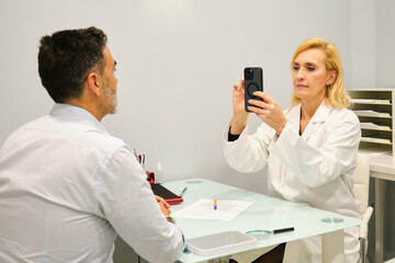 Aesthetic doctor woman taking a photo to the patient before the aesthetic treatment.