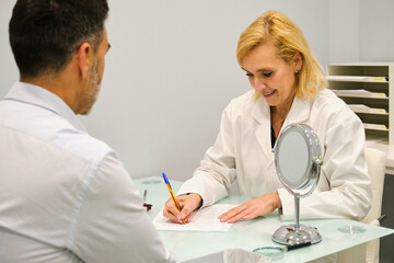 Aesthetic doctor woman writing patient personal data on a consent form in a aesthetic clinic.
