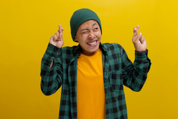 Excited young Asian man, dressed in a beanie hat and casual shirt, expresses enthusiasm by making a...
