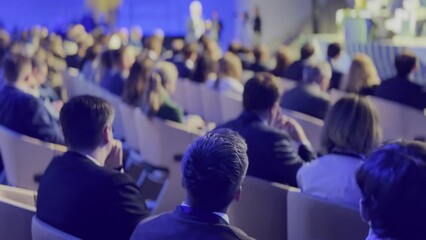 Focused group of business professionals attentively listening to a keynote speaker at a corporate conference event, embodying engagement and professionalism.