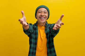 Friendly, smiling young Asian man extends his arms for a hug towards the camera, gesturing a COME...