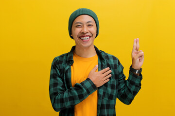 An earnest young Asian man, wearing a beanie hat and casual shirt, places his hand on his chest...