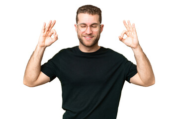 Young handsome blonde man over isolated chroma key background in zen pose