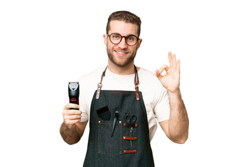 Barber man in an apron over isolated chroma key background showing ok sign with fingers