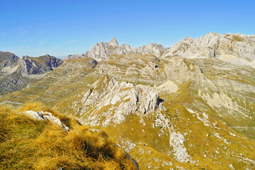 Relief in Durmitor, Montenegro: view from the top of Sedlena Greda to Bobotov Kuk and other peaks of the national park. Autumn landscape in blue and yellow colors.