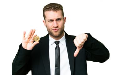 Young business blonde man holding a Bitcoin over isolated chroma key background showing thumb down with negative expression