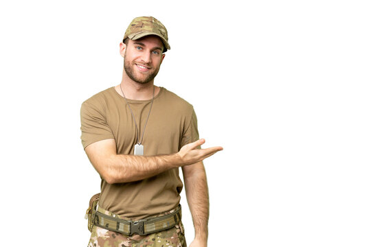 Military with dog tag over isolated chroma key background presenting an idea while looking smiling towards