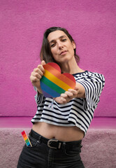 Body front view portrait of transgender lesbian woman with a rainbow heart to support LGBT community