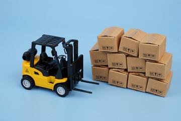 Нellow forklift truck and many carton boxes and Logistics, delivery and cargo concept.