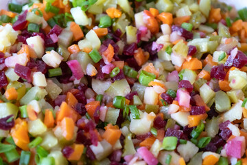 A tasty salad named Vinaigrette - a traditional Ukrainian and Russian  vegetable salad.  Vegetarian dish. Vegan food with green onion, boiled potatoes, carrot, beet. Salad background
