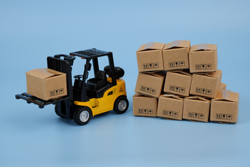 Carton boxes and yellow forklift truck. 