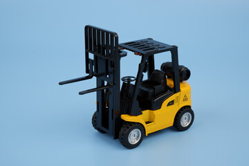 Yellow forklift truck model on blue background.