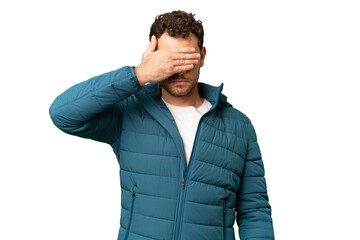 Brazilian man over isolated chroma key background covering eyes by hands. Do not want to see something