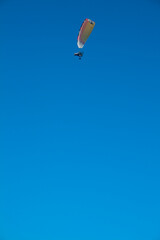 Paraglider with motor over the zenith of the observer and with blue sky in the background