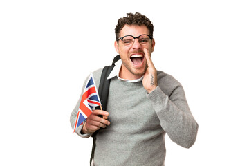 Brazilian man holding an United Kingdom flag over isolated chroma key background shouting with...