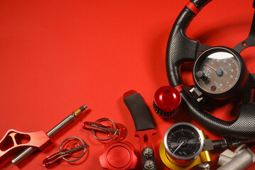 Sport car tuning equipment and spare parts on red top view background with copy space. Motorsport...